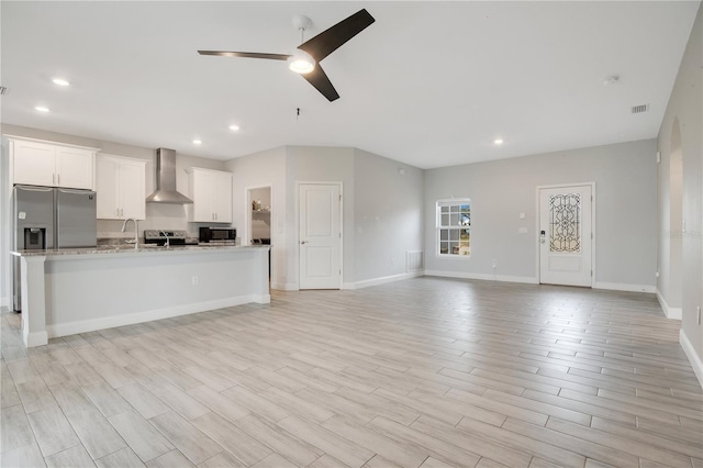 unfurnished living room with light hardwood / wood-style floors and ceiling fan