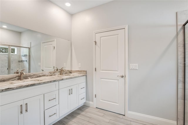 bathroom featuring vanity, an enclosed shower, and wood-type flooring