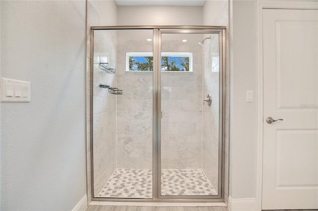 bathroom with a shower with door