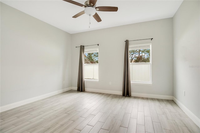 empty room featuring plenty of natural light, ceiling fan, and light wood-type flooring