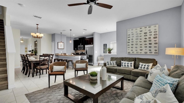 living room with sink and ceiling fan with notable chandelier