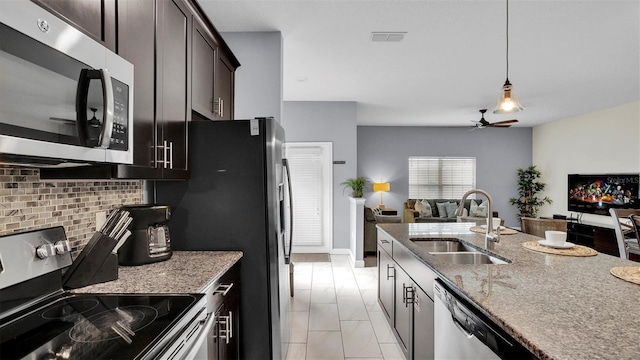 kitchen featuring dark brown cabinetry, sink, pendant lighting, stainless steel appliances, and backsplash