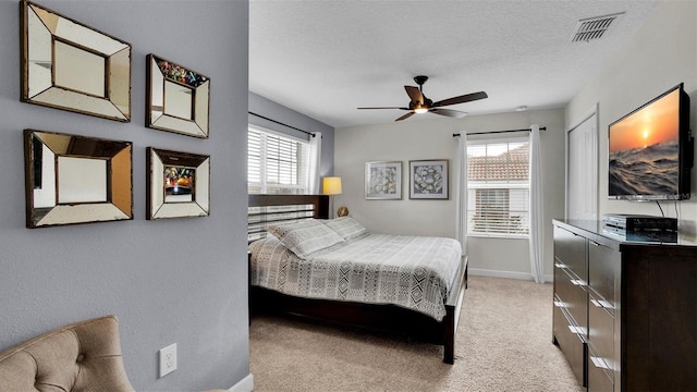 bedroom featuring light colored carpet and a textured ceiling