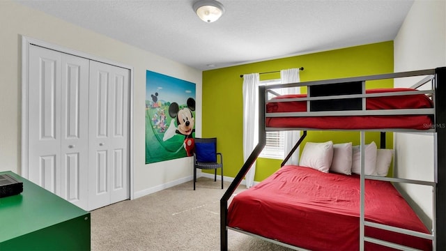 carpeted bedroom with a closet and a textured ceiling