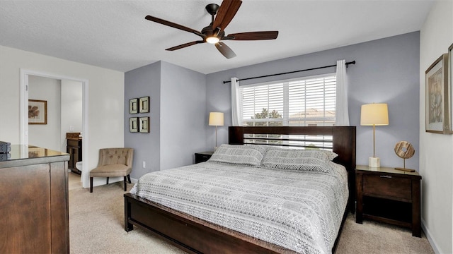 carpeted bedroom featuring ceiling fan and a textured ceiling