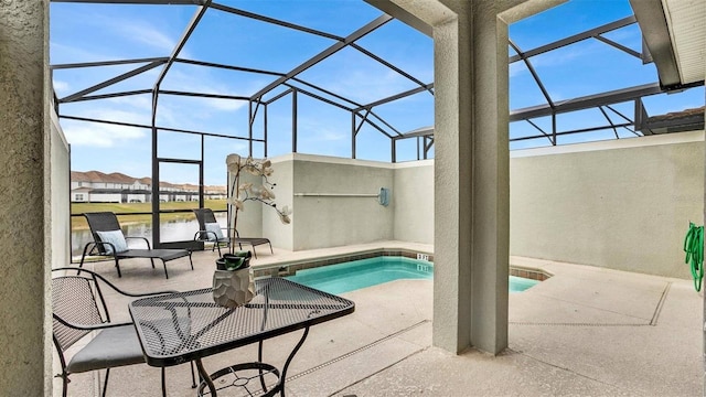 view of swimming pool with a water view, a patio, and glass enclosure