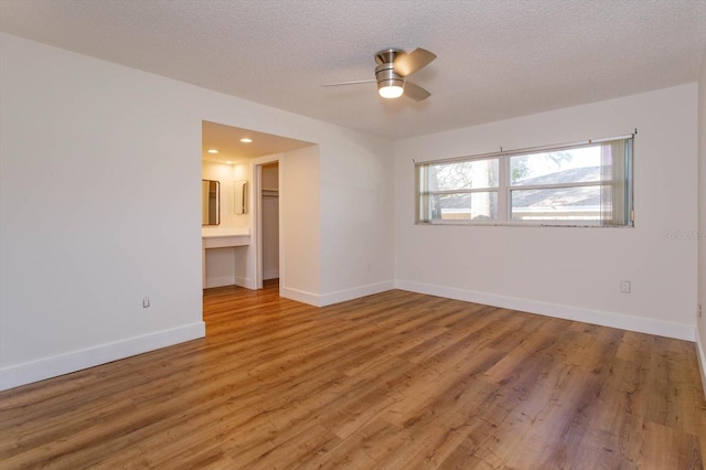 spare room with hardwood / wood-style floors, a textured ceiling, and ceiling fan