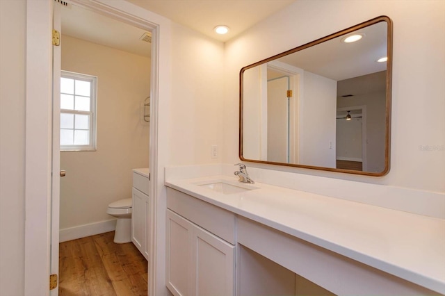 bathroom with hardwood / wood-style flooring, vanity, and toilet