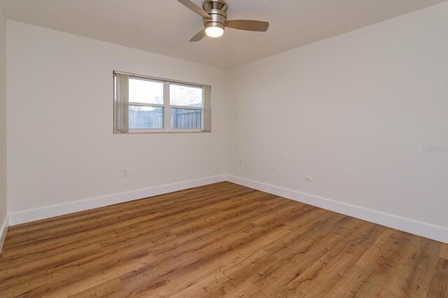 unfurnished room with ceiling fan, light hardwood / wood-style flooring, and a textured ceiling