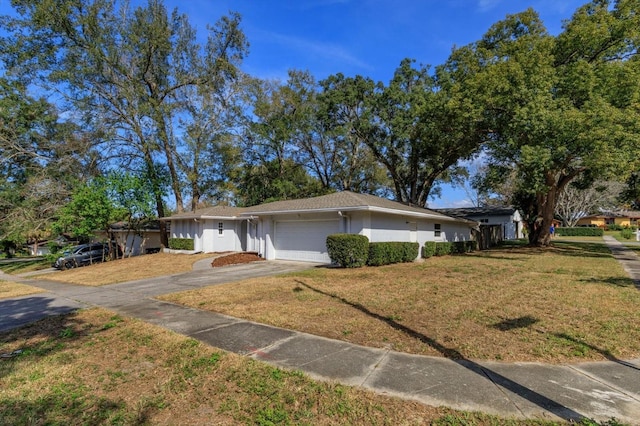 ranch-style house featuring a garage and a front lawn