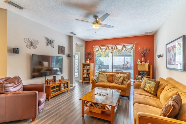 living room featuring ceiling fan, wood-type flooring, and a textured ceiling