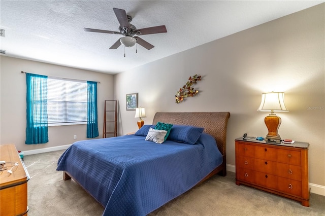 bedroom featuring ceiling fan, light colored carpet, and a textured ceiling