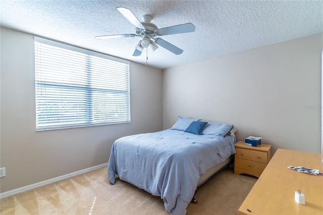 carpeted bedroom with ceiling fan and a textured ceiling