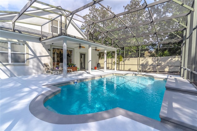 view of swimming pool featuring a patio, ceiling fan, and glass enclosure