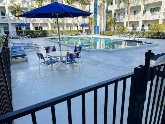 community pool featuring a patio and fence