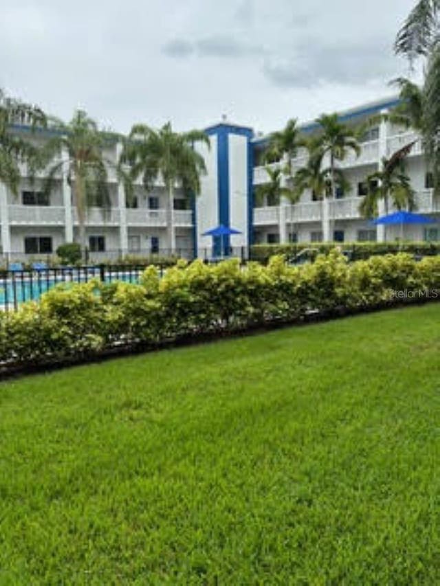 view of community featuring a pool and a yard