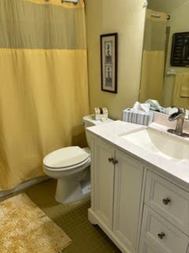 bathroom featuring vanity, tile patterned flooring, and toilet