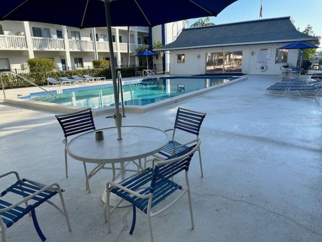 community pool featuring a patio and fence