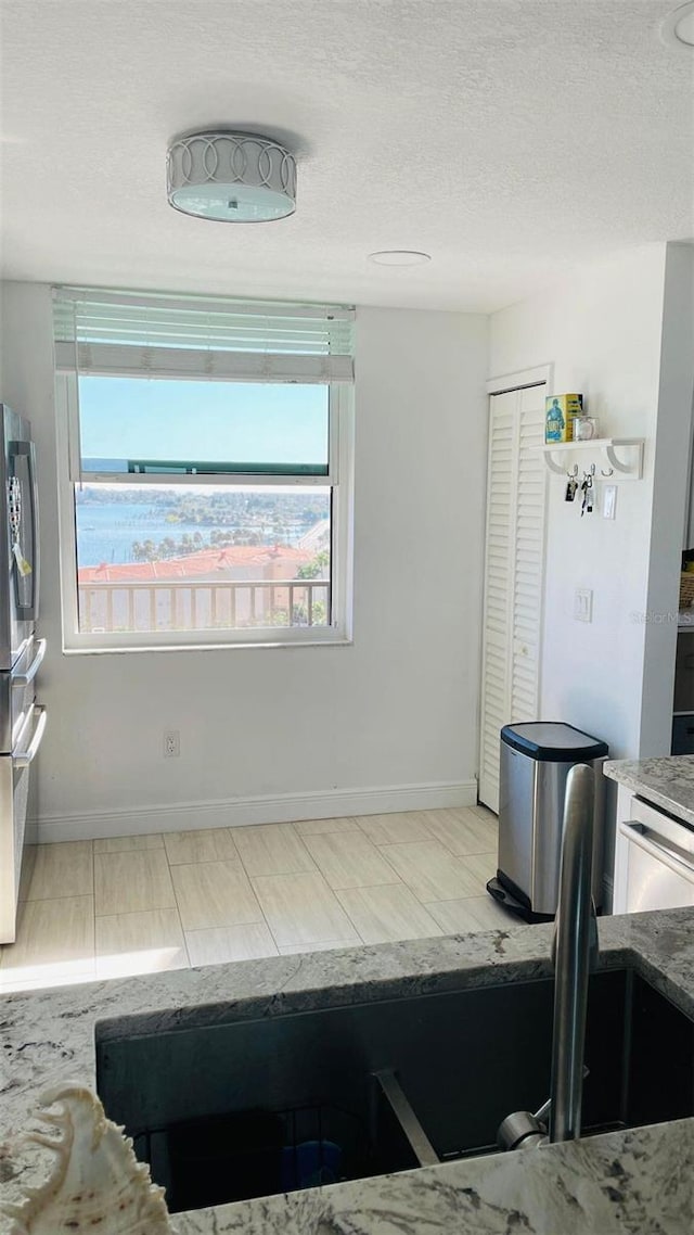 interior space featuring stainless steel appliances and a textured ceiling