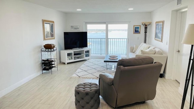 living area featuring recessed lighting, visible vents, and baseboards