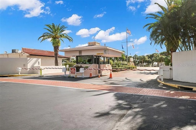 view of road with curbs and a gated entry