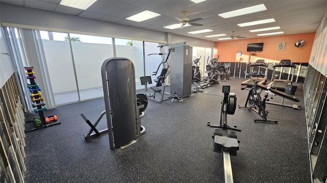 exercise room with a drop ceiling and a ceiling fan