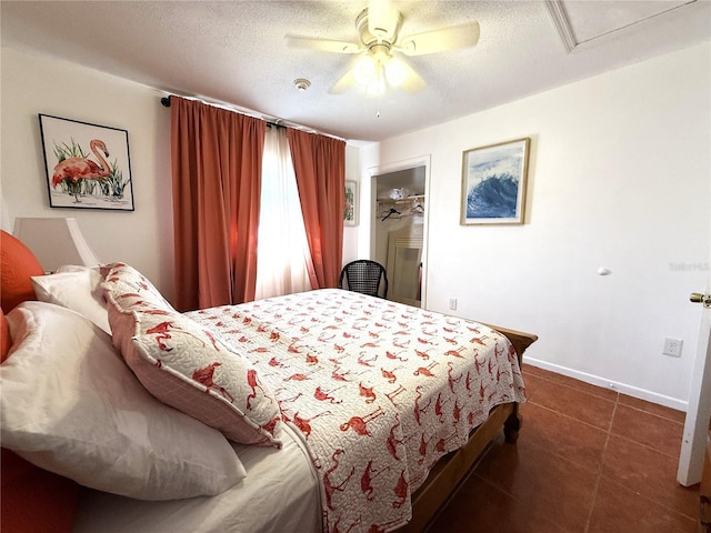 tiled bedroom with ceiling fan and a textured ceiling