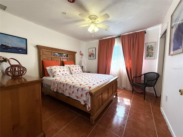 tiled bedroom featuring ceiling fan and a textured ceiling