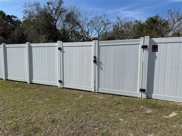 view of gate with a yard