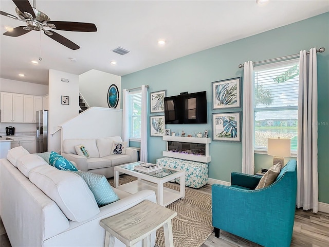 living room featuring ceiling fan and light hardwood / wood-style flooring