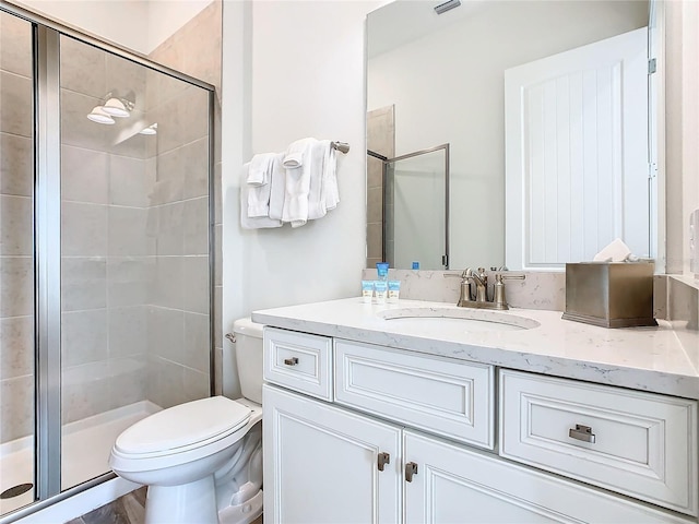 bathroom featuring vanity, toilet, and walk in shower