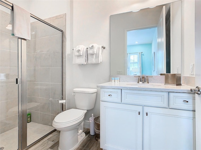 bathroom with vanity, hardwood / wood-style floors, toilet, and walk in shower