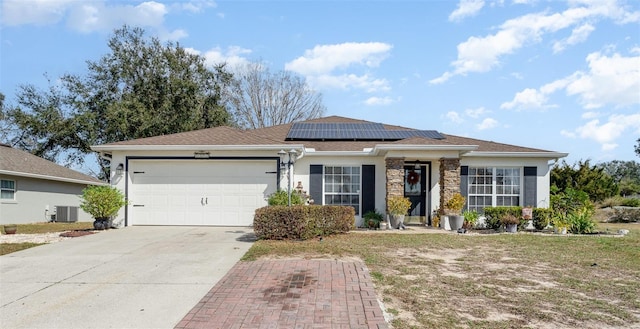 ranch-style house with a garage, central AC, and solar panels