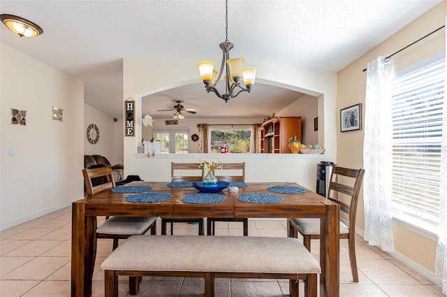 dining room featuring light tile patterned flooring, ceiling fan with notable chandelier, and a textured ceiling