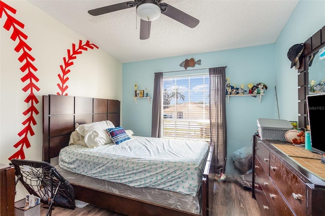 bedroom featuring wood-type flooring, ceiling fan, and a textured ceiling