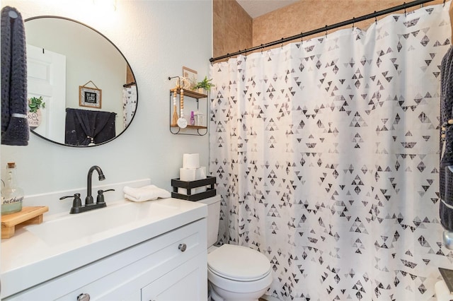 bathroom featuring walk in shower, vanity, and toilet