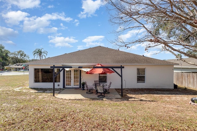 back of house with a patio, a lawn, and french doors