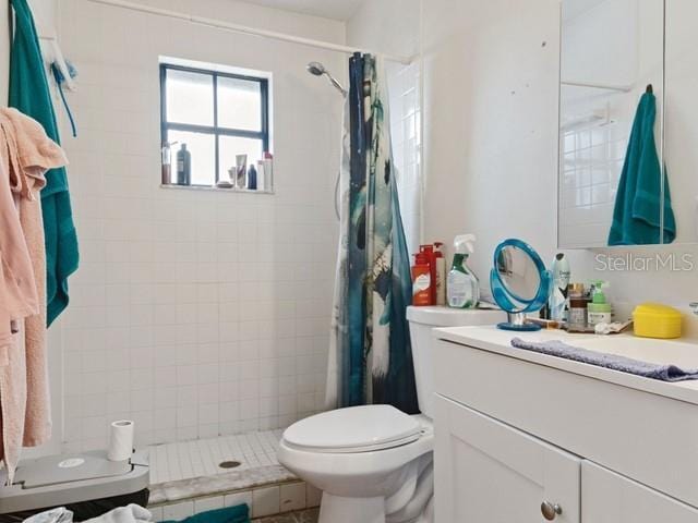 bathroom with a shower with curtain, vanity, and toilet