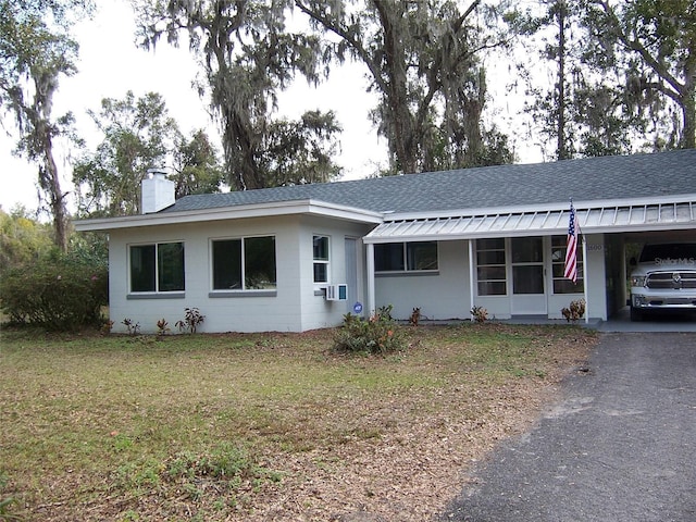 ranch-style home featuring a carport and a front yard