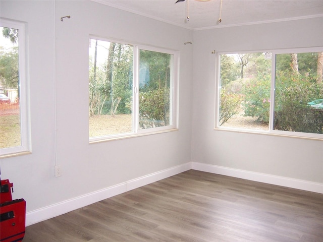 unfurnished room with crown molding, dark hardwood / wood-style floors, and ceiling fan