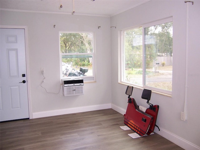 spare room featuring hardwood / wood-style flooring, ornamental molding, and a wall unit AC