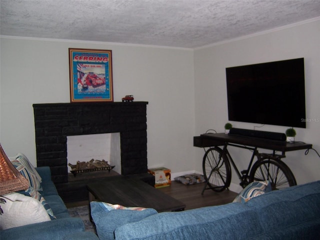 living room featuring wood-type flooring, a brick fireplace, a textured ceiling, and crown molding