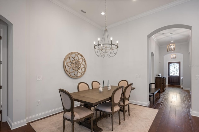 dining room with hardwood / wood-style floors, ornamental molding, and a chandelier