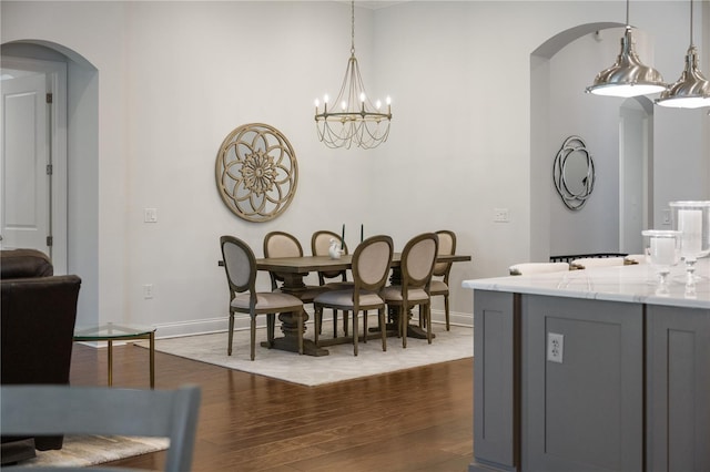 dining room with dark hardwood / wood-style floors and a chandelier