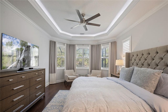 bedroom featuring a raised ceiling, crown molding, dark wood-type flooring, and ceiling fan