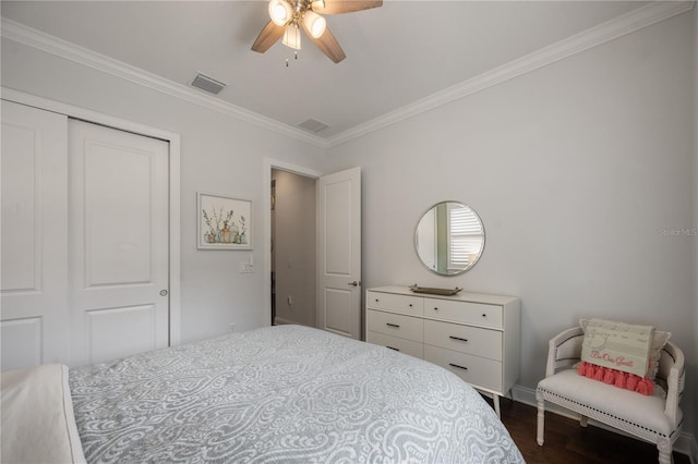 bedroom with crown molding, dark hardwood / wood-style floors, ceiling fan, and a closet