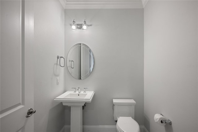 bathroom with sink, ornamental molding, and toilet