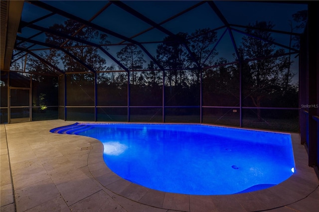 view of swimming pool featuring a lanai and a patio