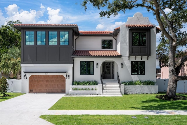 mediterranean / spanish house with a garage and a front yard