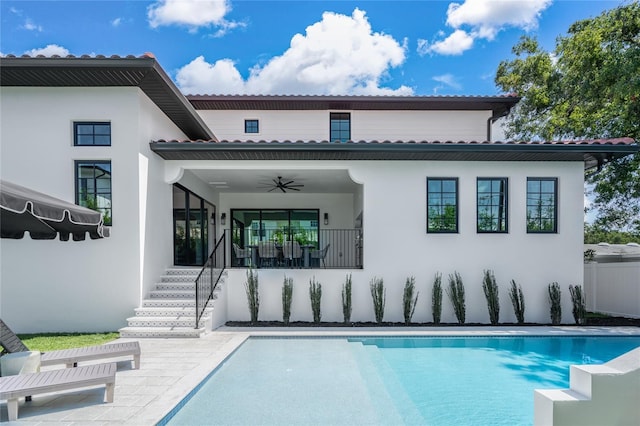 rear view of property featuring a fenced in pool, a patio, and ceiling fan